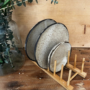 light colored wood plate drying rack with pegs