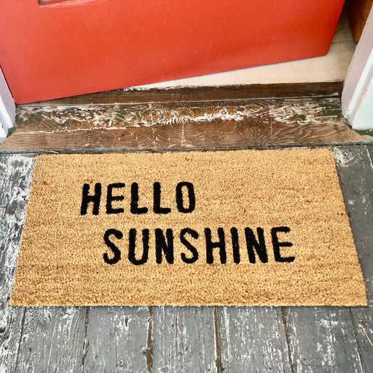 tan door mat with words "hello sunshine" in black