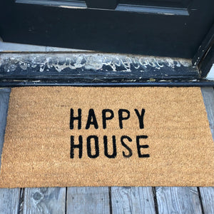 tan door mat with words "happy house"  in black