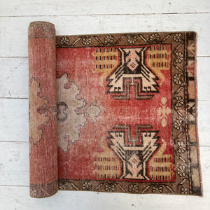 red, tan and brown patterned small Turkish rug