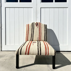 armless chair with natural feedback fabric that has black and rust stripes and simple patterns....black legs