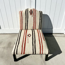Load image into Gallery viewer, armless chair with natural feedback fabric that has black and rust stripes and simple patterns....black legs