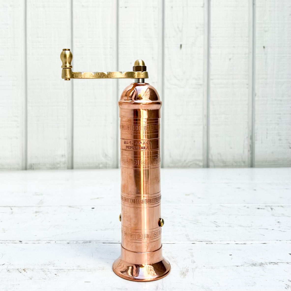 copper salt and pepper grinder with brass crank handles on the top