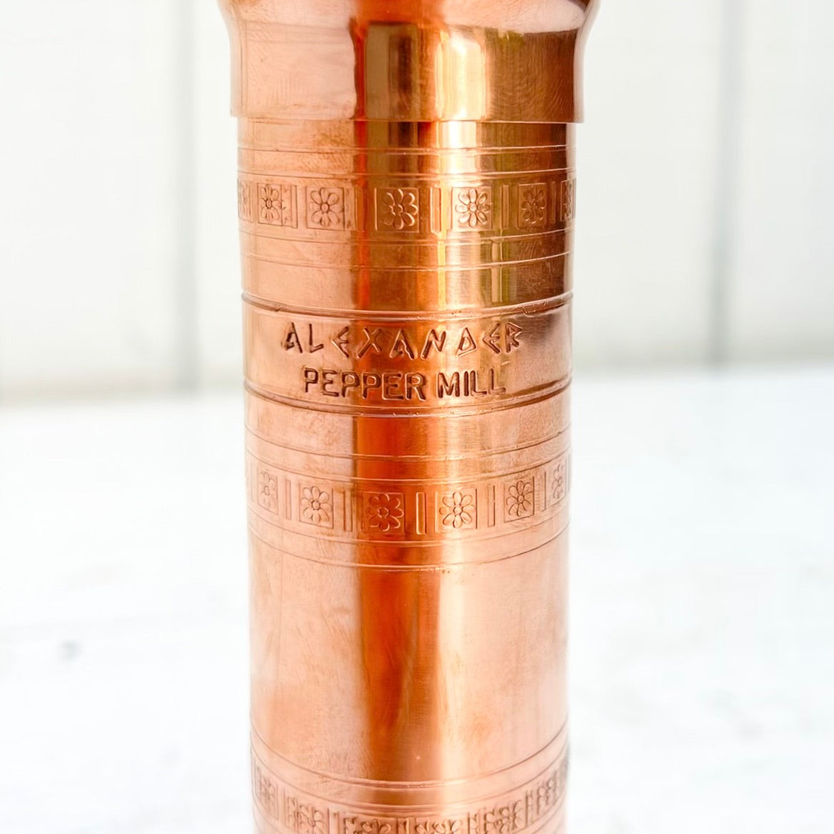 copper salt and pepper grinder with brass crank handles on the top