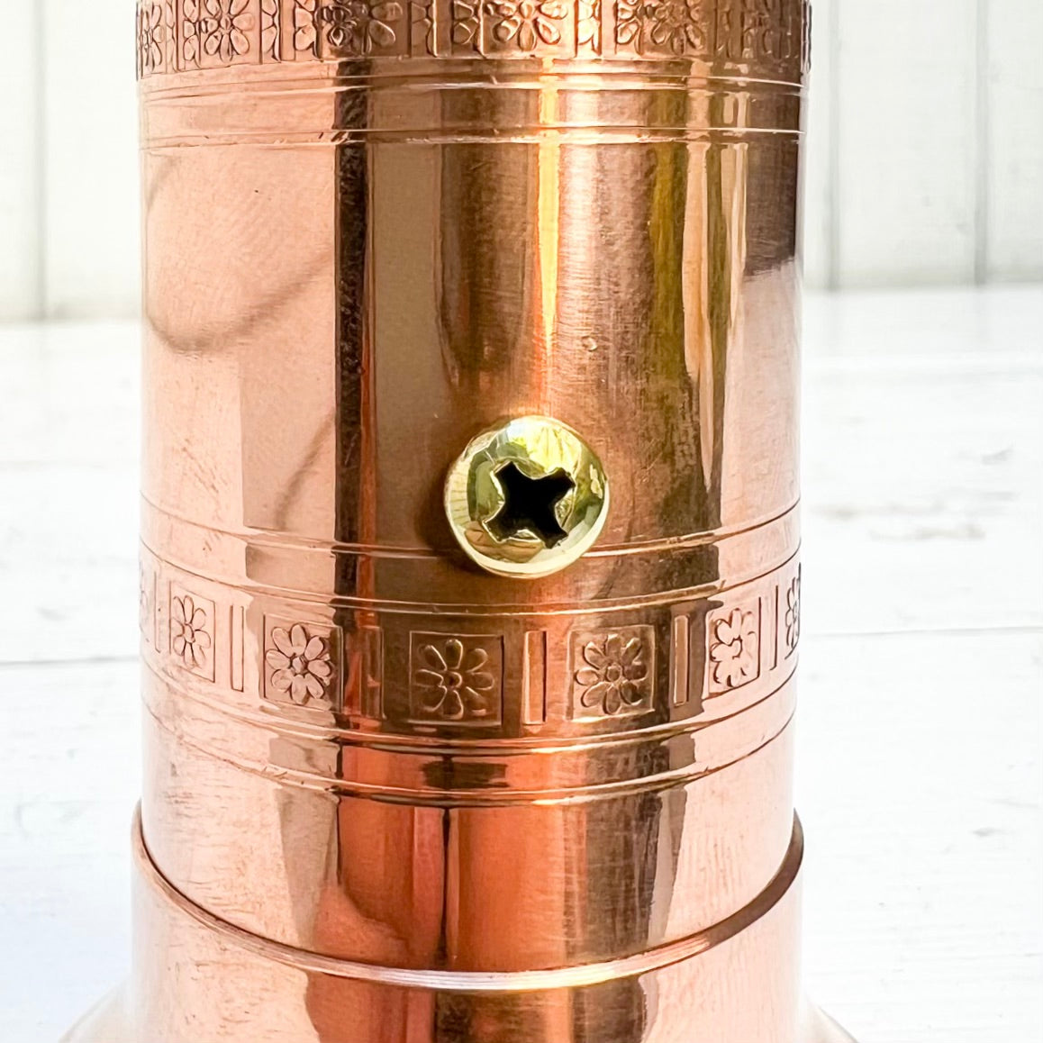 copper salt and pepper grinder with brass crank handles on the top