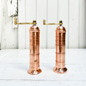 copper salt and pepper grinder with brass crank handles on the top