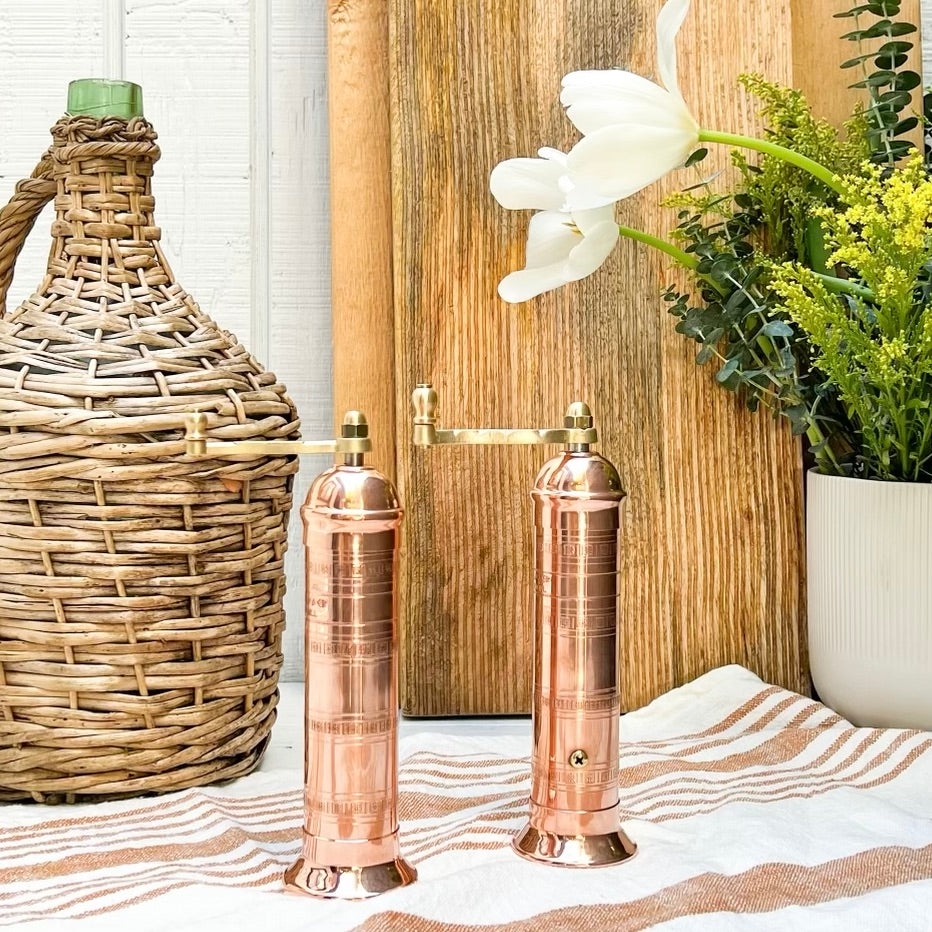 copper salt and pepper grinder with brass crank handles on the top