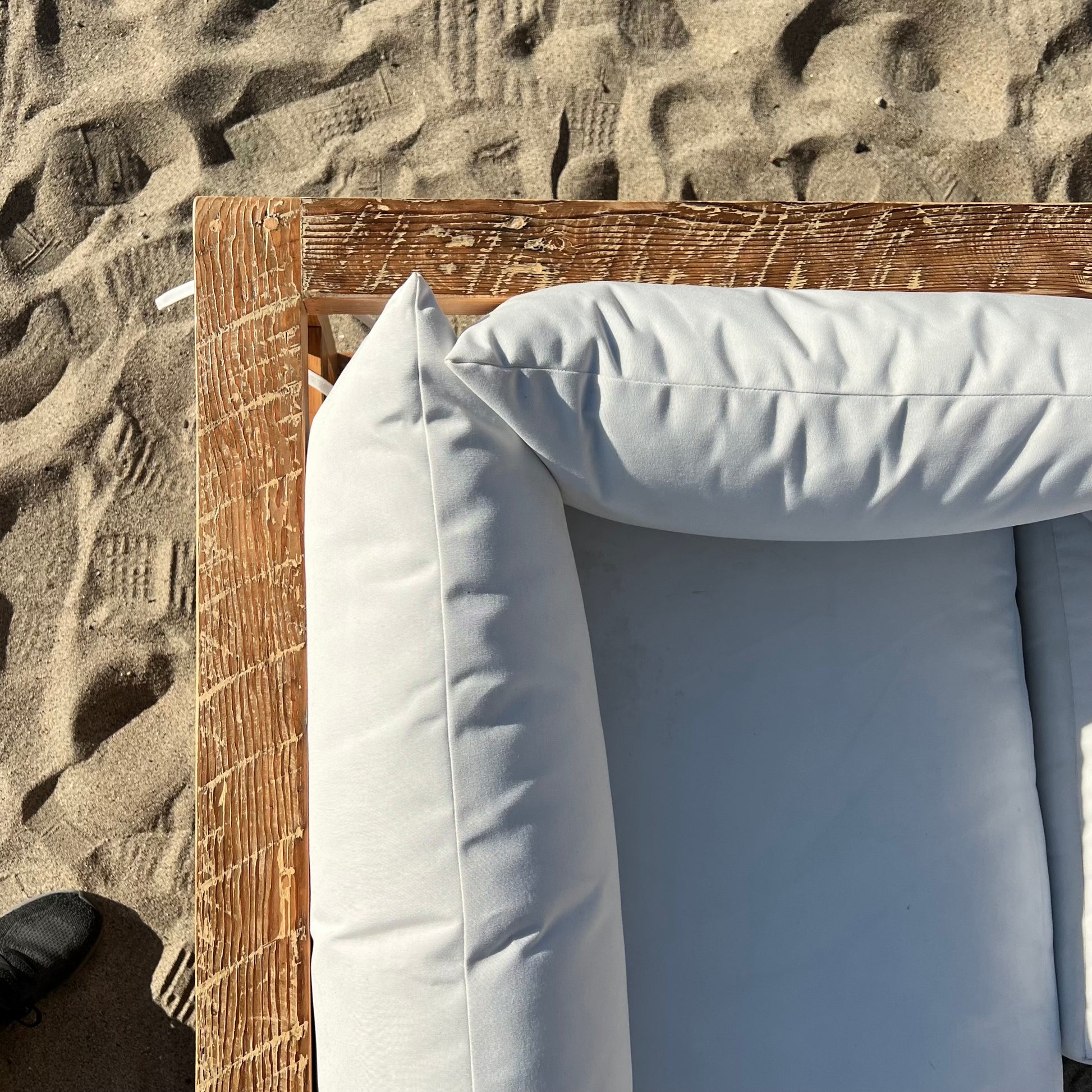 sectional sofa made of repurposed wood, off white cushions with outdoor fabric, medium brown wood color