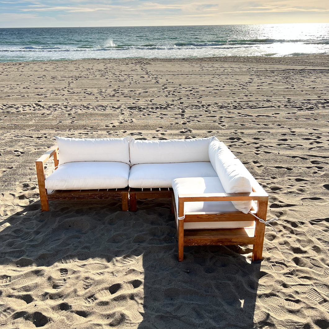 sectional sofa made of repurposed wood, off white cushions with outdoor fabric, medium brown wood color