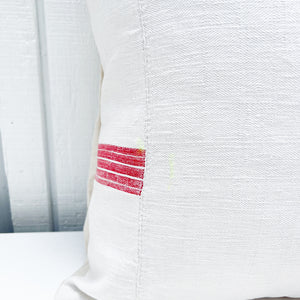 white square pillow with red stripes on edges