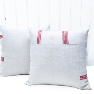 white square pillow with red stripes on edges