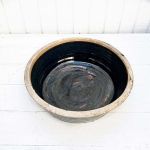 shiny black glazed ceramic bowl with rustic unglazed rim