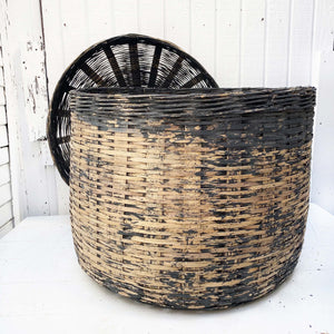 large charcoal colored wicker basket with some color worn off in middle, with lid