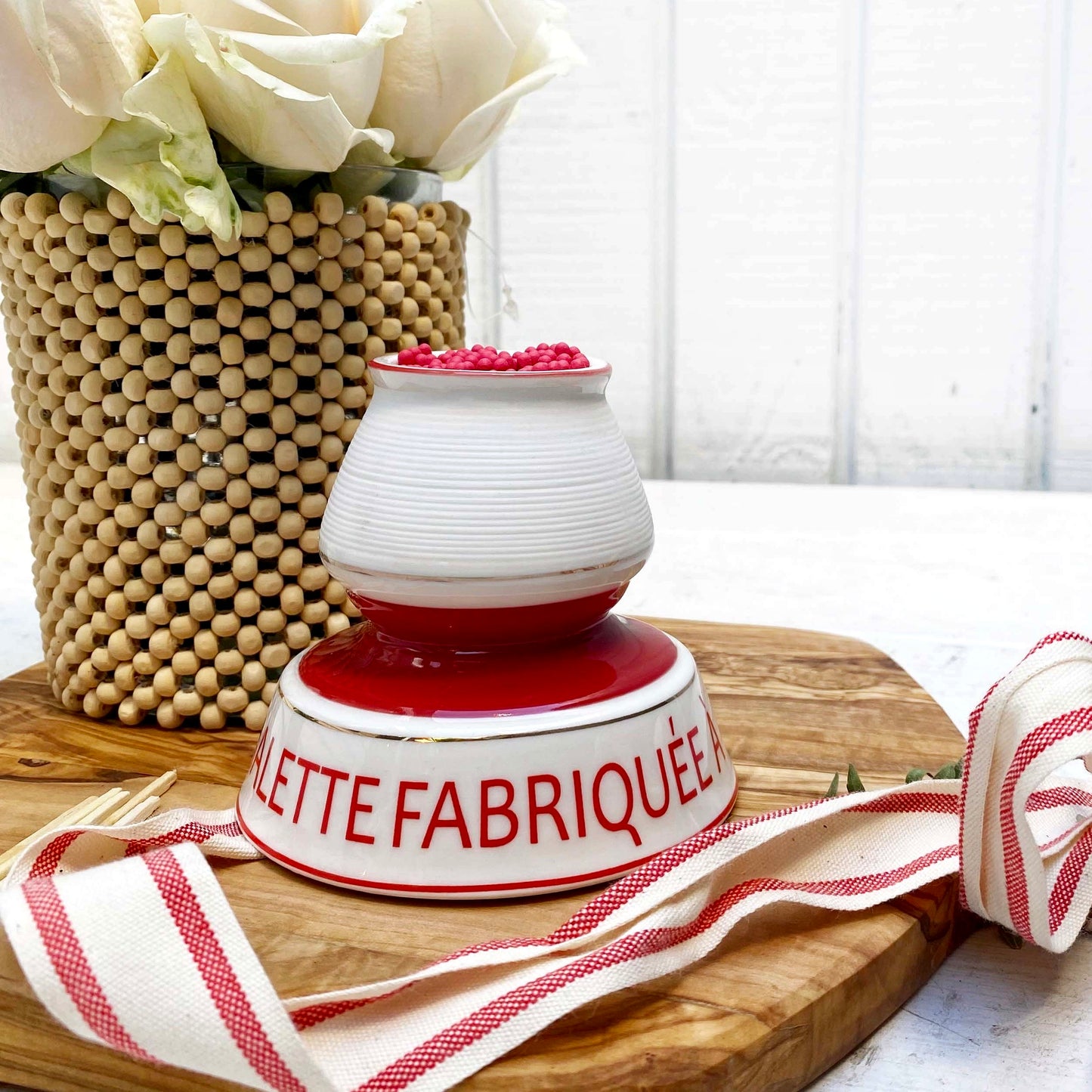 white and red ceramic match strike holder with red French lettering