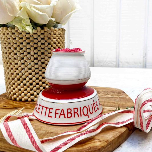 white and red ceramic match strike holder with red French lettering