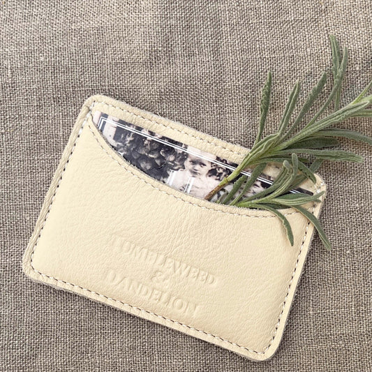cream colored credit card holder with "Tumbleweed and Dandelion" imprinted
