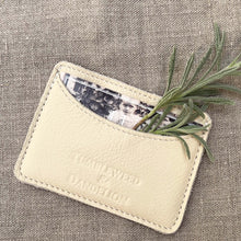 Load image into Gallery viewer, cream colored credit card holder with &quot;Tumbleweed and Dandelion&quot; imprinted
