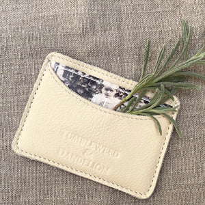 cream colored credit card holder with "Tumbleweed and Dandelion" imprinted