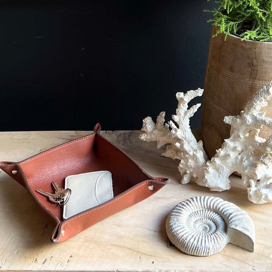 brown leather catch all dish with "Tumbleweed & Dandelion" imprinted in the center