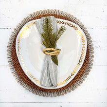 Load image into Gallery viewer, brown rattan placemat with cream colored shells on edges
