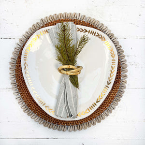 brown rattan placemat with cream colored shells on edges