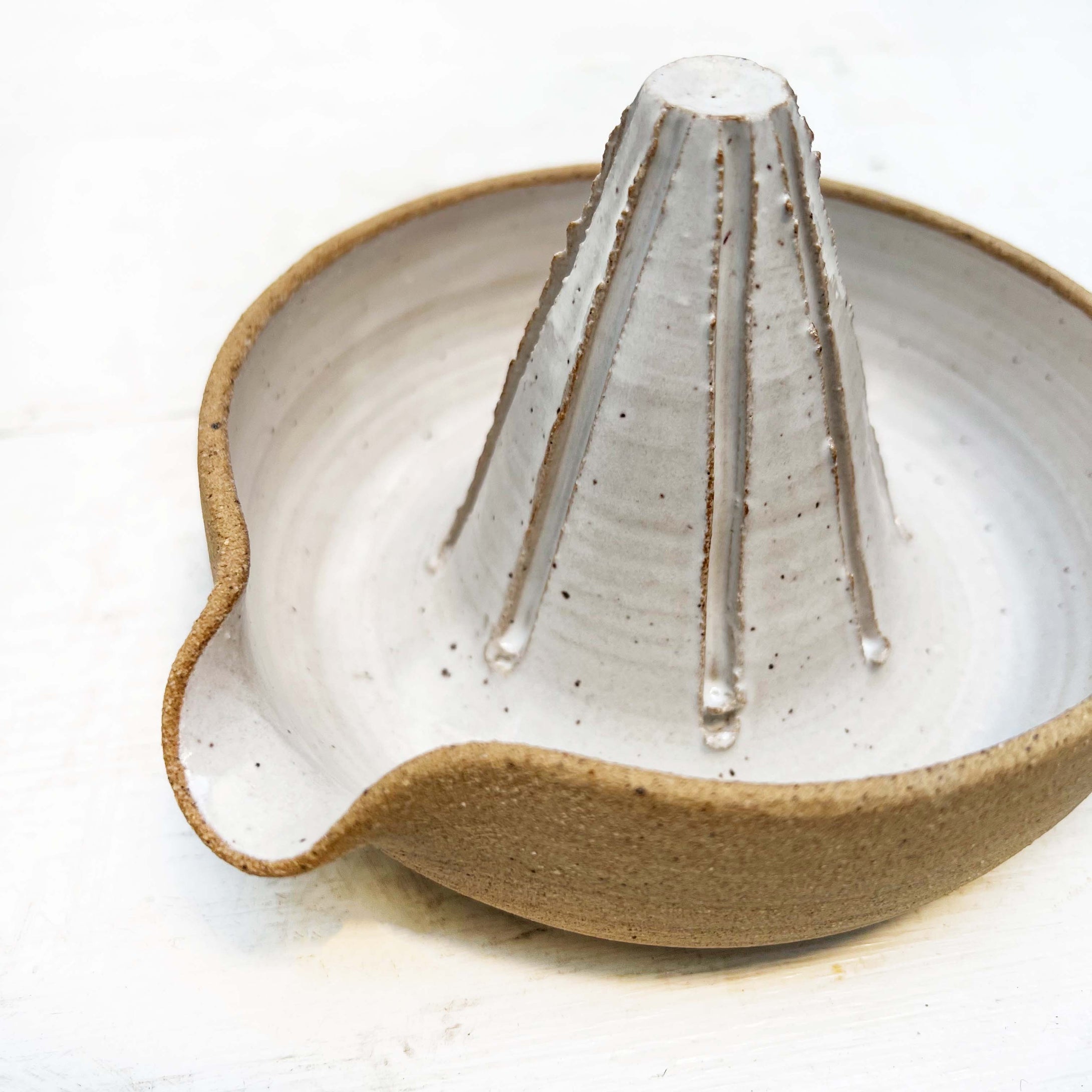 white glazed ceramic hand juicer