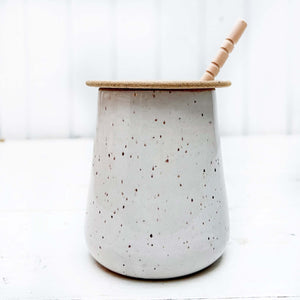 ceramic jar with lid and wooden honey dipper