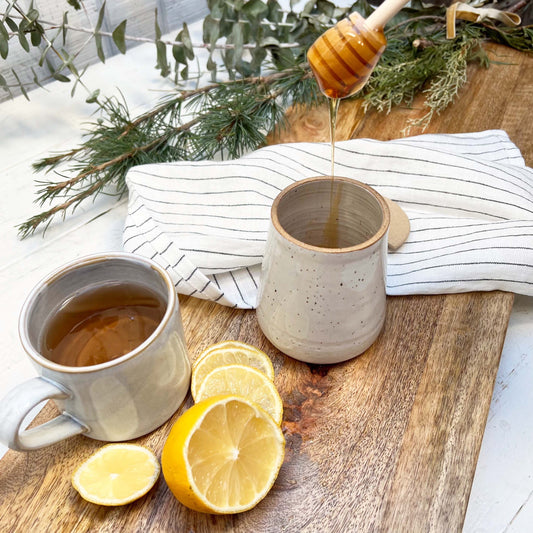 ceramic jar with lid and wooden honey dipper