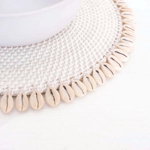 white rattan placemat with off white shells on edges