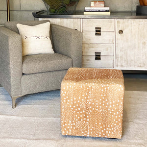 amber and white patterned mud cloth upholstered cube ottoman