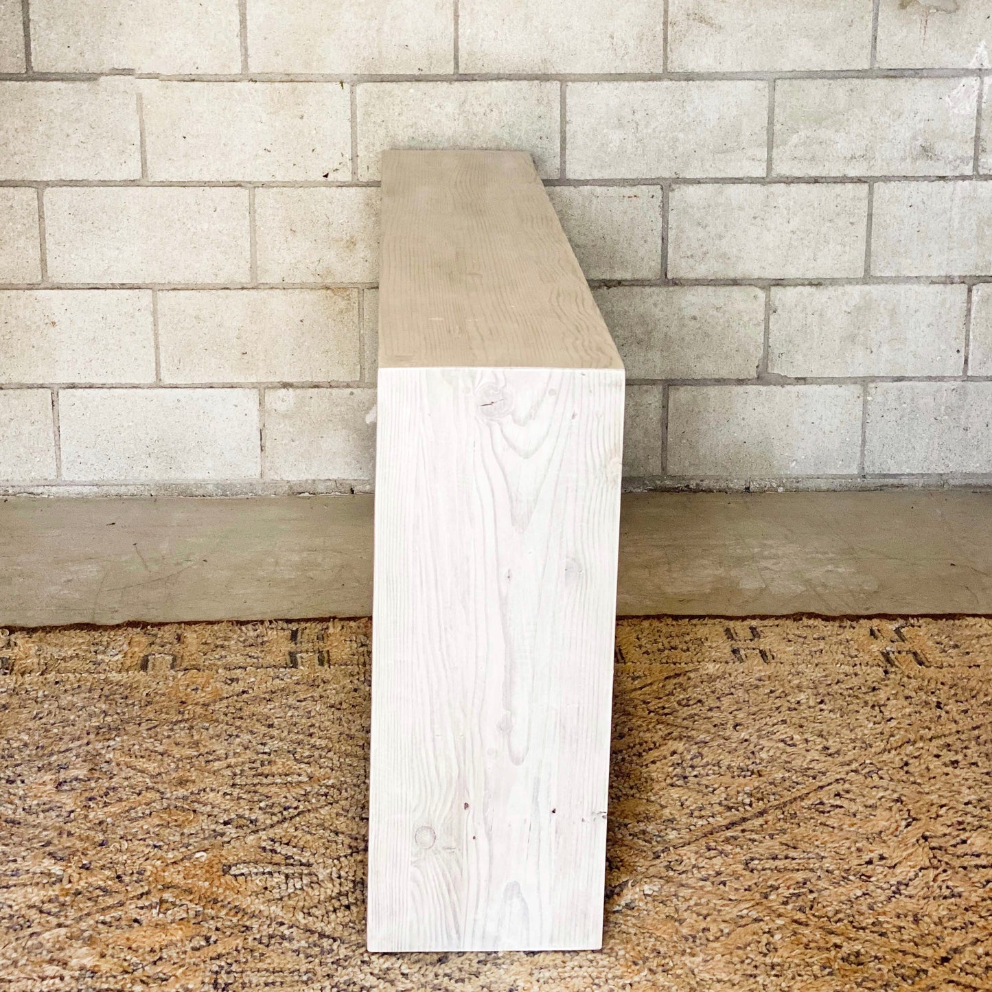 clean line bleached wooden entryway table with bar along bottom