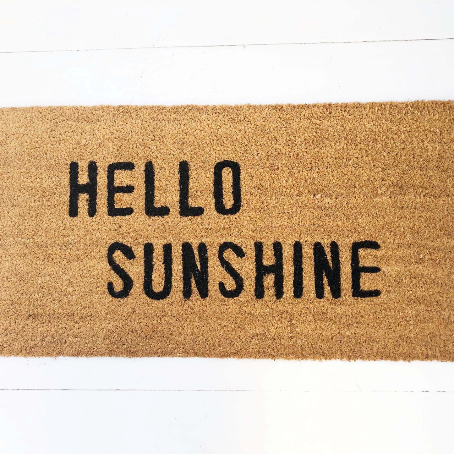 tan door mat with words "hello sunshine" in black