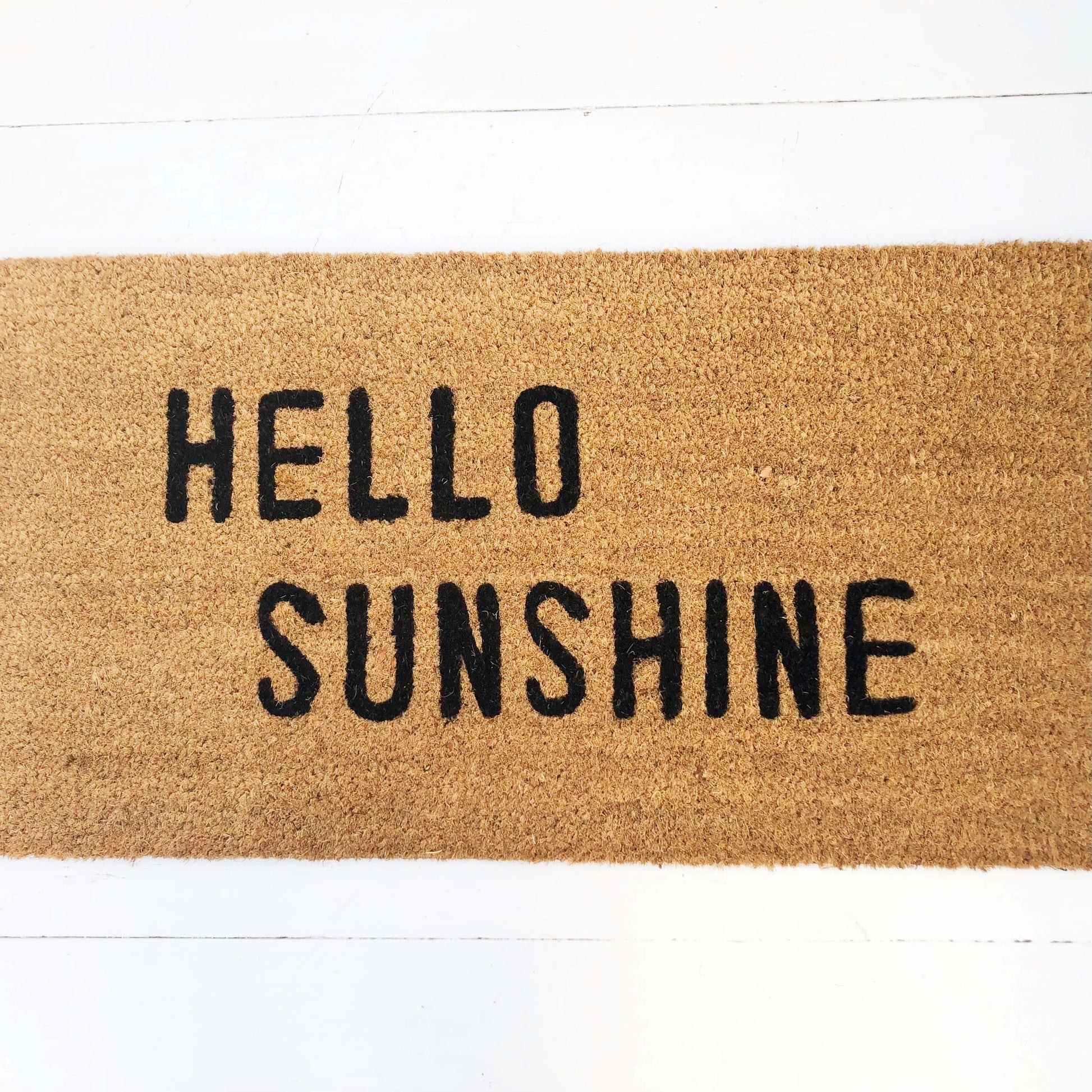 tan door mat with words "hello sunshine" in black