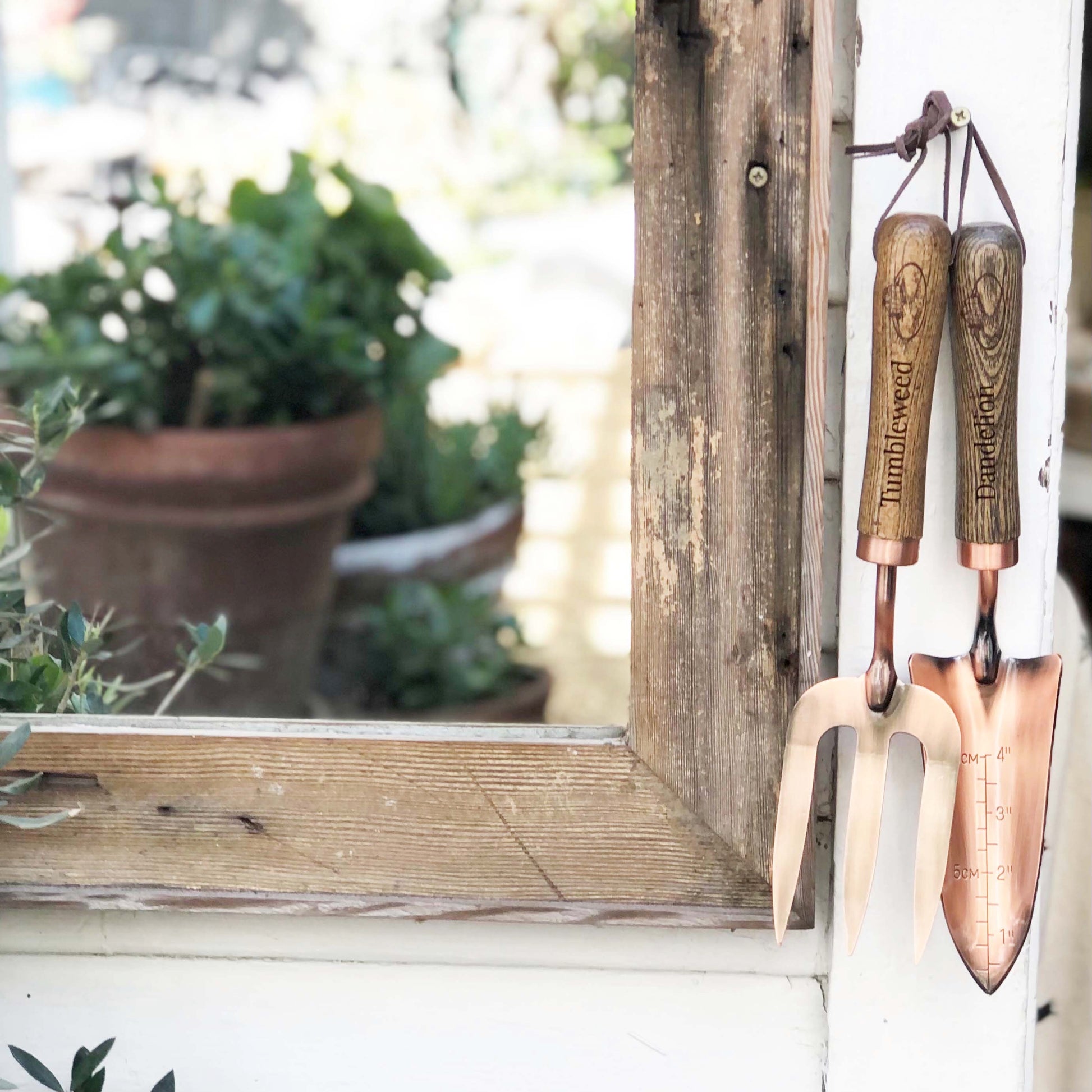copper fork and trowel garden tool set with wooden handles imprinted with "Tumbleweed" on fork and "Dandelion" on the trowel