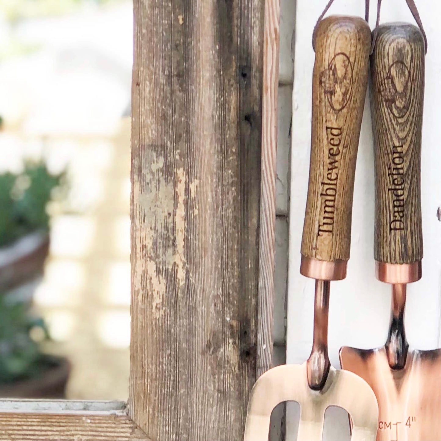 copper fork and trowel garden tool set with wooden handles imprinted with "Tumbleweed" on fork and "Dandelion" on the trowel