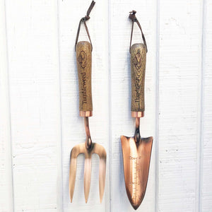 copper fork and trowel garden tool set with wooden handles imprinted with "Tumbleweed" on fork and "Dandelion" on the trowel