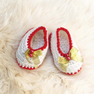 handmade knit white baby booties with red trim and gold bow