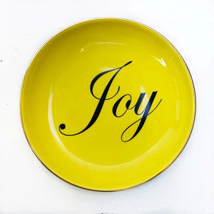 yellow round dish with word "joy" in black