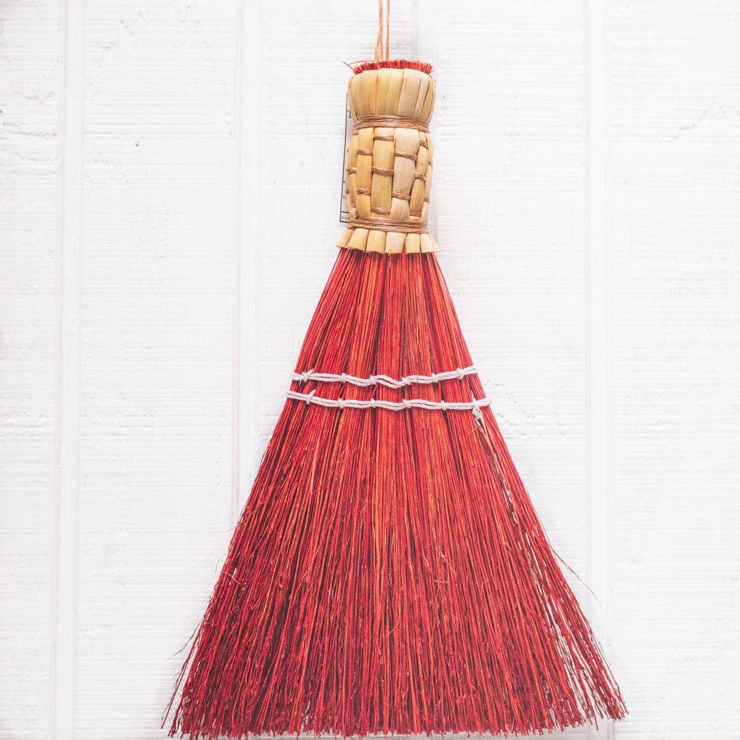 small red hand held whisk broom