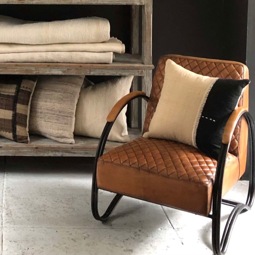 caramel brown colored leather side chair with quilted leather seat and black iron frame