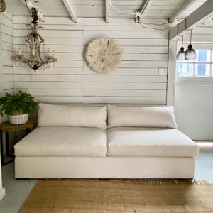 off white armless upholstered sofa with two seat and two back cushions, made with Boucle fabric