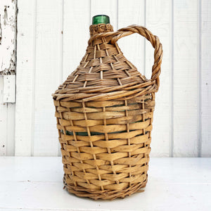green glass wine jug wrapped in wicker with handle