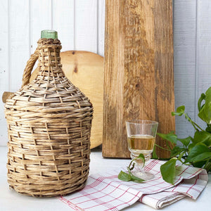 green glass wine jug wrapped in wicker with handle