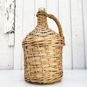 green glass wine jug wrapped in wicker with handle
