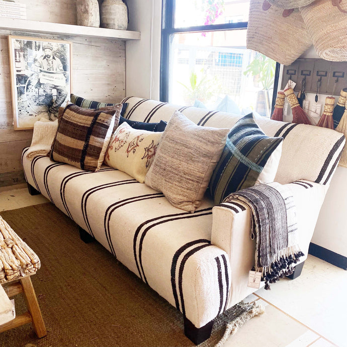 upholstered sofa in cream feed sack fabric with black stripes