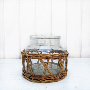 glass container wrapped in brown wicker