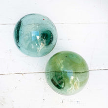 Load image into Gallery viewer, round green/blue glass balls, some with rope around them