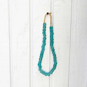 turquoise glass beads on a strand of jute