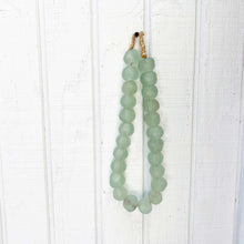 Load image into Gallery viewer, pale green glass beads on a strand of jute