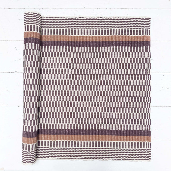 brown and white rug with brown and striped border
